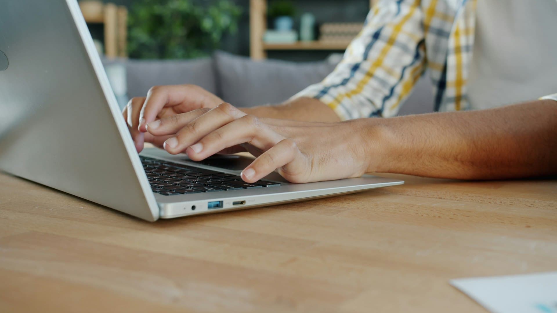 Hands typing on a laptop keyboard